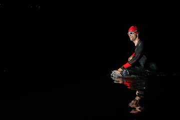 Image showing Authentic triathlete swimmer having a break during hard training on night