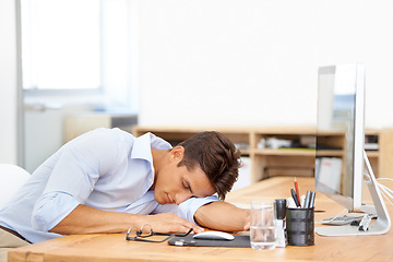 Image showing Businessman, sleeping and computer on desk at office in fatigue, burnout or mental health. Tired man or employee asleep or taking a nap in relax or rest sitting on chair or table by PC at workplace