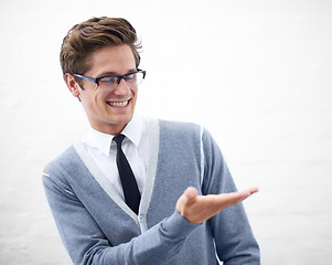 Image showing Man, hand and businessman in fashion, smile and offering for work, professional and employee. Product placement, marketing geek and pointing as manager and business attire of person in corporate wear