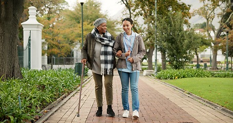 Image showing Help, cane and nurse with old woman in park for relax, support and person with a disability. Elderly care, conversation and healthcare with caregiver and patient in nature for medical rehabilitation