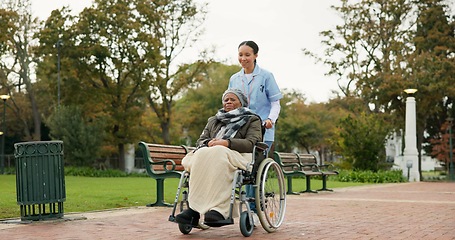 Image showing Nurse, walking and park with old woman in a wheelchair for retirement, elderly care and physical therapy. Trust, medical and healthcare with senior patient and caregiver in nature for rehabilitation