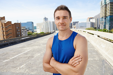 Image showing Man, arms crossed in city and exercise outdoor with workout, training and athlete in portrait for sports. Confidence, face and fitness on urban bridge, health and wellness with sportswear in Chicago