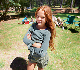 Image showing Girl, kid and arms crossed in portrait summer camp and nature with fun outdoor for youth. Child at campsite in forest, adventure and vacation, childhood and recreation with happiness and smile