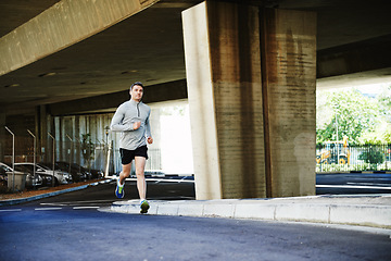 Image showing Man, runner and fitness on road in outdoor, cardio and exercise or training for marathon. Male person, athlete and workout by city background, sportswear and performance challenge by bridge on street