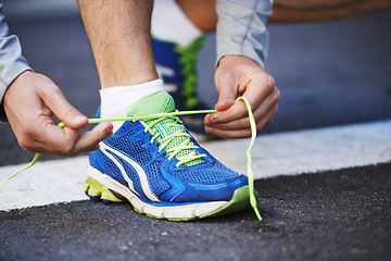 Image showing Foot, runner and tying laces on street in outdoors, cardio and exercise or training for marathon. Person, athlete and ready for workout in closeup, sportswear and performance challenge on asphalt