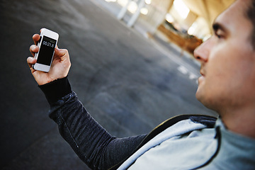 Image showing Man, runner and checking phone in outdoors, screen and exercise or training for marathon. Male person, athlete and workout by city background, mobile app and performance challenge or timer on tech