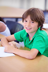 Image showing Portrait, happy child or student in classroom for knowledge, education or development for future growth. School, smart boy or clever kid with book, smile or pride for studying or learning at desk