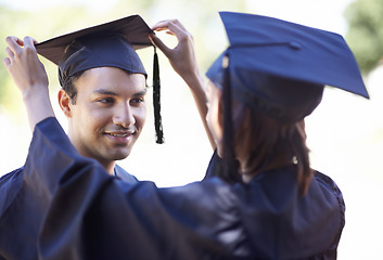 Image showing Couple, graduate and woman fix man graduation cap, education and academic success with ceremony. Certification, achievement and event at university with people together for milestone and award