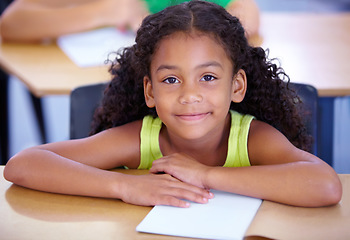 Image showing Portrait, girl child or student in classroom for knowledge, education or development for future growth. Scholarship, back to school or happy kid with book or pride for studying or learning at desk