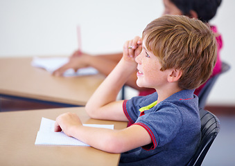 Image showing Learning, happy child or student in classroom for knowledge, education or development for growth. School, smart boy or clever male kid with book, smile or pride for studying, focus or future at desk