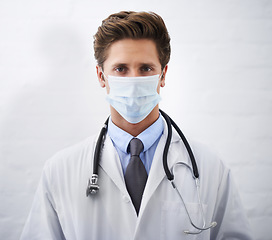 Image showing Man, portrait and doctor with face mask for protection, health and safety on mockup space. Male person, surgeon or medical professional with stethoscope for healthcare on a white studio background