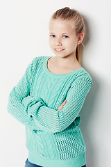 Image showing Child, portrait and fashion pride in studio, cool and confidence by white background. Female person, girl and casual clothing or style by backdrop, kid and trendy winter sweater or smiling face