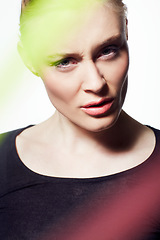 Image showing Face, woman and beauty with light streak, confused or frown, creativity glow and skin on white background. Neon color, bright or shine with headshot, makeup and art deco, model with doubt in studio