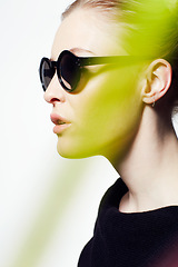 Image showing Woman, profile with sunglasses for fashion and light streak, cosmetics or makeup, creativity and neon glow on white background. Art deco, beauty and bright color in studio, style and dark eyewear