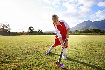 Image showing Girl, green grass and playing hockey for sports, game or outdoor match in nature for practice. Female person, kid or playful child enjoying competition with ball on field for fitness or training