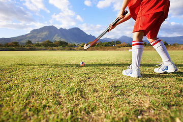 Image showing Person, green grass and playing hockey for game, outdoor match or sports in nature for practice. Closeup of child, kid or player enjoying competition with ball on field for fitness training outside