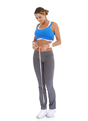 Image showing Woman, stomach and measure tape in studio for diet, weight loss and health results or fitness progress. Sports person smile and check body in exercise, workout or training goals on a white background