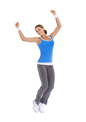 Image showing Woman, jump and fitness celebration in studio for exercise success, workout achievement or body goals and dance. Sports model with fist, energy and portrait for training results on a white background