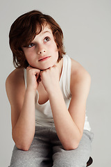 Image showing Thinking, fashion and boy child in a studio with dreaming, reflection or memory face expression. Youth, style and young kid model with casual, stylish and trendy outfit isolated by gray background.