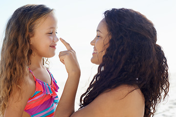 Image showing Happy mother, girl and poking nose at beach for love, care or support for child or daughter in nature. Mom and cute young kid smile for touch, sense or sunscreen at ocean or outdoor sea by the coast