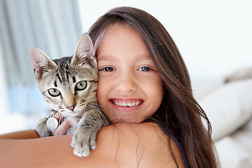 Image showing Smile, cat and portrait of child at her home cuddling, hugging and bonding with her animal. Happy, love and face of young girl kid embracing her kitten pet with care in living room of family home.