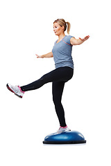 Image showing Woman, stretching and balance on bosu ball for exercise, workout or training on a white studio background. Active female person on half round object for pilates, practice or health on mockup space