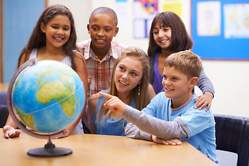 Image showing Students, children with globe and learning map in classroom for education, teaching and quiz or group support. Happy kids with planet earth, world and geography for 3d knowledge of history in school