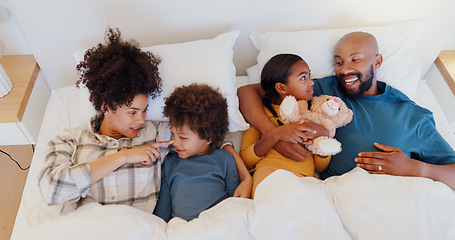 Image showing Happy, relax and children with parents in bed of home for bonding together with teddy bear and top. Smile, fun and young interracial man and woman laying for rest with kids in bedroom of family house