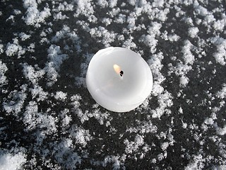 Image showing white lit candle on ice