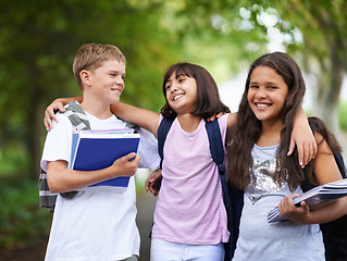 Image showing Happy kids, friends and hug walking with backpack in park for unity, teamwork or school together. Group of young people smile in nature with bag and books for learning or education in outdoor forest