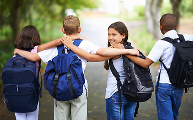 Image showing Happy students, friends and hug with backpack in park for unity, teamwork or walking to school together. Rear view of young group in nature with bags for learning or education in outdoor forest