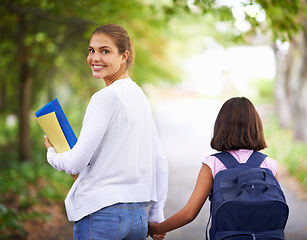 Image showing Happy woman, teacher and walking student to school in park or outdoor forest for support or responsibility. Female person, educator smile and holding hands with learner, kid or young child in nature