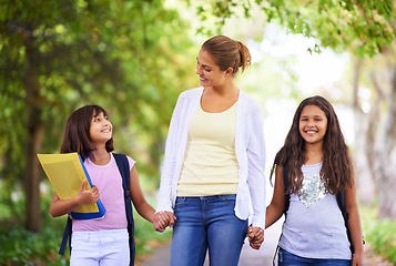 Image showing Happy teacher, students and holding hands walking to school in outdoor park for support or responsibility. Woman, person or educator smile with learner, kids or young children with backpack in nature