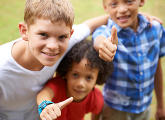 Image showing Happy children, portrait and thumbs up in nature for teamwork, winning or good job together at park. Group of casual young boys smile and hug with like emoji, yes sign or OK for outdoor success