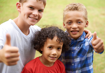 Image showing Happy children, portrait and thumbs up for outdoor teamwork, winning or good job together in nature. Group of casual young boys smile and hug with like emoji, yes sign or OK for success at the park