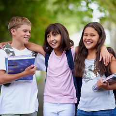 Image showing Happy children, friends and hug with backpack in park for unity, teamwork or walking to school together. Group of young kids smile in nature, bag or books for learning or education at outdoor forest