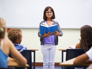 Image showing Classroom, child and reading a book in presentation, information and education by whiteboard. Girl, student and learning or studying for assessment, literature and notebook for story and knowledge