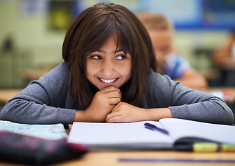 Image showing Girl, education and happy in classroom for learning, information and notes for knowledge in school. Female person, book and confidence for assessment or test, studying lesson and smiling at academy