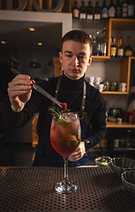 Image showing Barmen is decorating cocktail