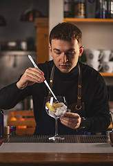 Image showing Young man bartender works