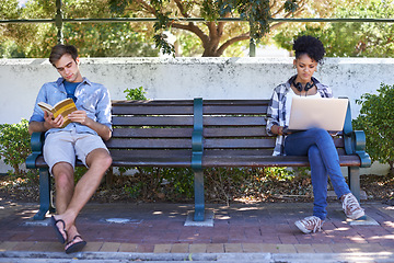 Image showing College, campus and students in the park study on a bench with laptop, book and reading. University, academy and people sitting outdoor learning with research, project and knowledge for education