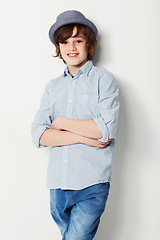 Image showing Boy, confidence and portrait for fashion in studio, cool clothing and arms crossed by white background. Happy male person, child and cool hat by backdrop or pride for style, face and trendy outfit