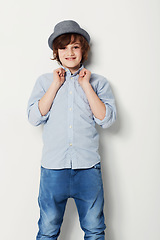 Image showing Child, boy and portrait for fashion in studio, cool clothing and confidence by white background. Happy male person, kid and cute hat by backdrop or pride for style, face and trendy outfit or relaxing