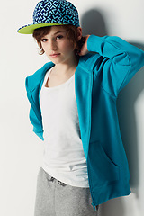 Image showing Portrait, fashion and confident child in a hoodie in studio isolated on a white background. Trendy style, cool kid and cap of young boy in a hat, casual clothes and serious on a backdrop in Sweden