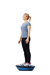 Image showing Woman, balance ball and standing for training, exercise or workout on white studio background. Active female person or athlete on half round object for fitness, health and wellness mockup space