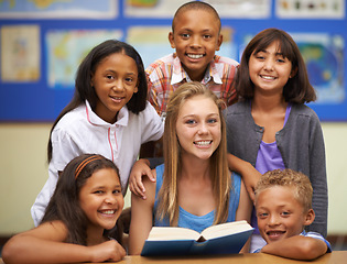 Image showing Children, tutor and portrait with group in classroom for knowledge, learning or education with happiness. Face, student and woman at school with study, textbook and smile with diversity at college