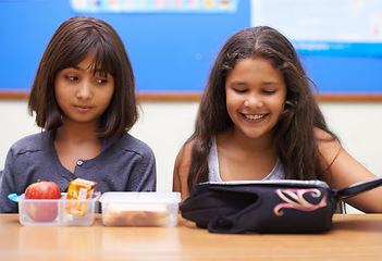 Image showing Happy kids, students and eating food in classroom at school for meal, break or snack time. Young little girls or elementary children smile with lunch bag for health, nutrition or vitamins in class