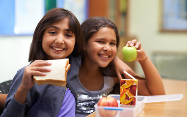 Image showing Girls, happy and portrait with lunch at school for recess, break or nutrition at table with diversity. Kids, face and smile at academy or relax with confidence, food or embrace for friendship or care