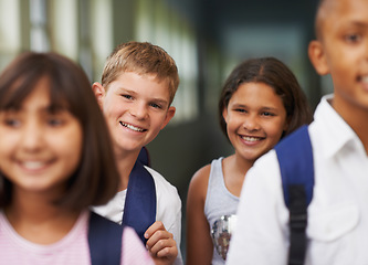 Image showing Boy, portrait and friends in corridor or happy with backpack or pride for learning, education or knowledge. Student, people and face with smile in building or hallway before class or ready to study