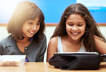 Image showing Happy children, students and eating food in classroom at school for meal, break or snack time. Young little girls or elementary kids smile with lunch bag for health, nutrition or vitamins in class